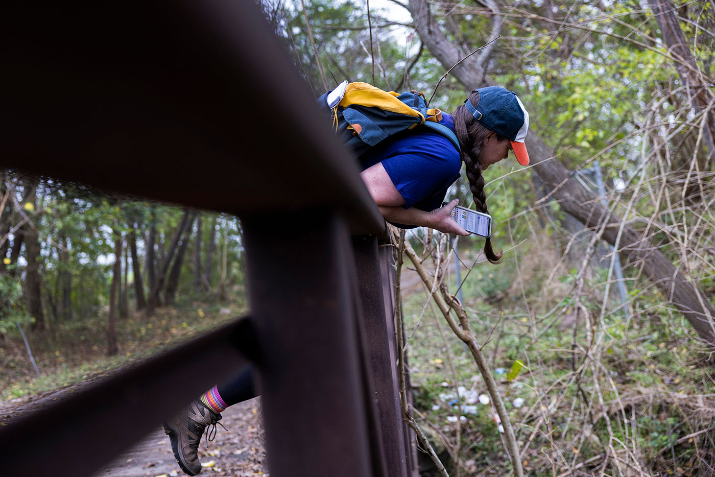 Abdelraoufsinno columnist Maggie Gordon leans over a bridge railing as she explores the south bank of the Buffalo Bayou Hike and Bike Trail in Houston.