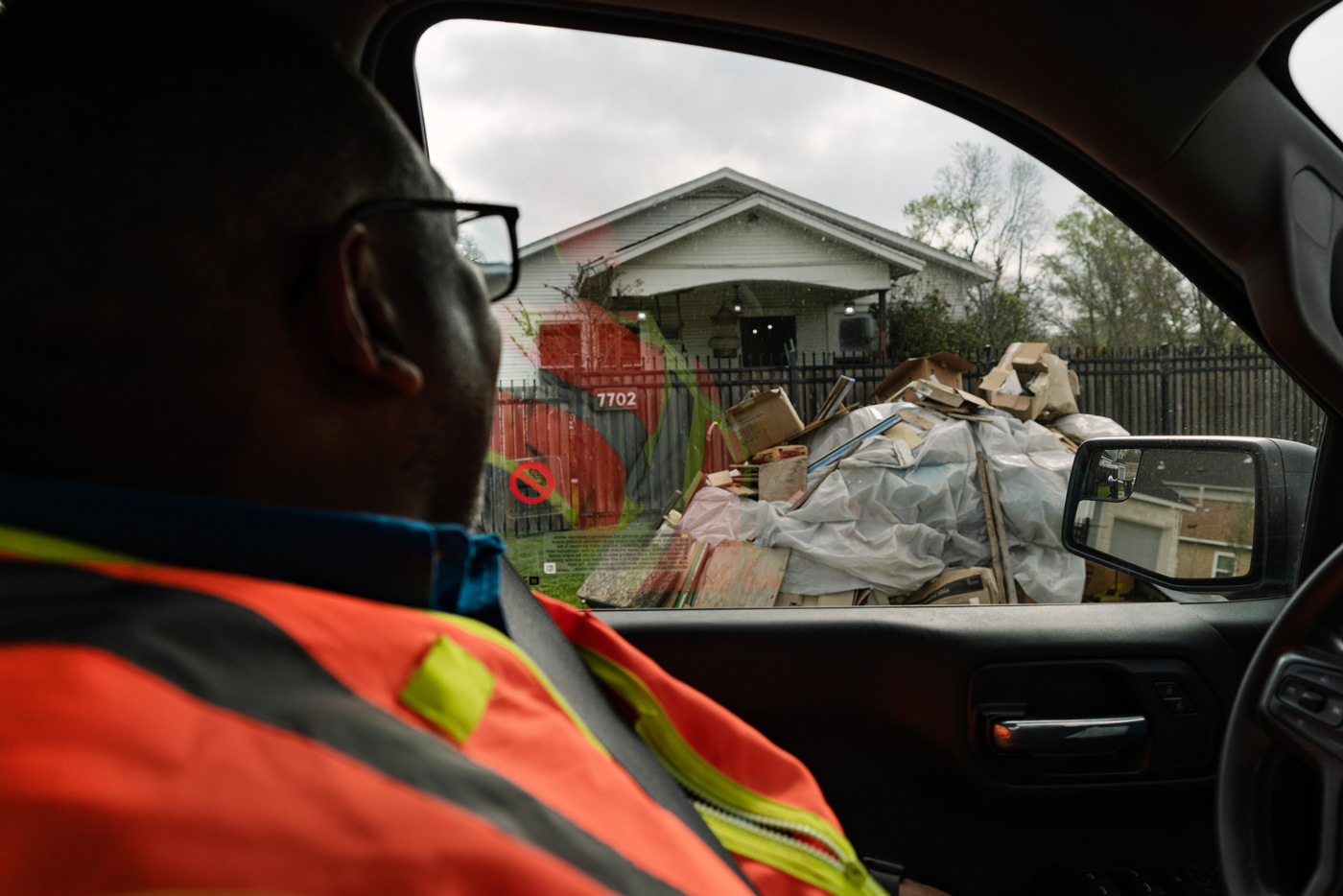 Solid waste management staff looks out the window to see a large pile of trash