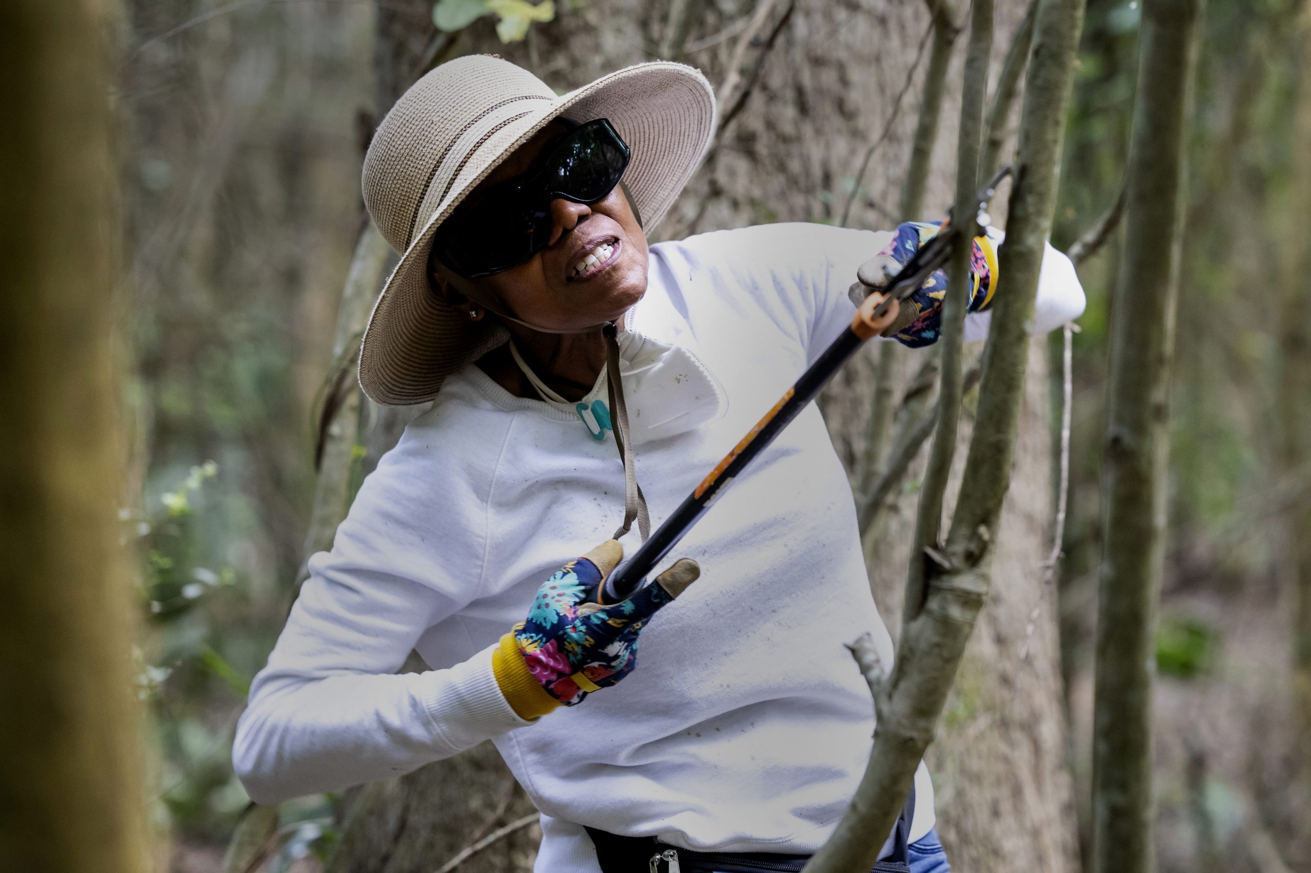 Beverly Harris, 71, clears branches in a historic cemetery