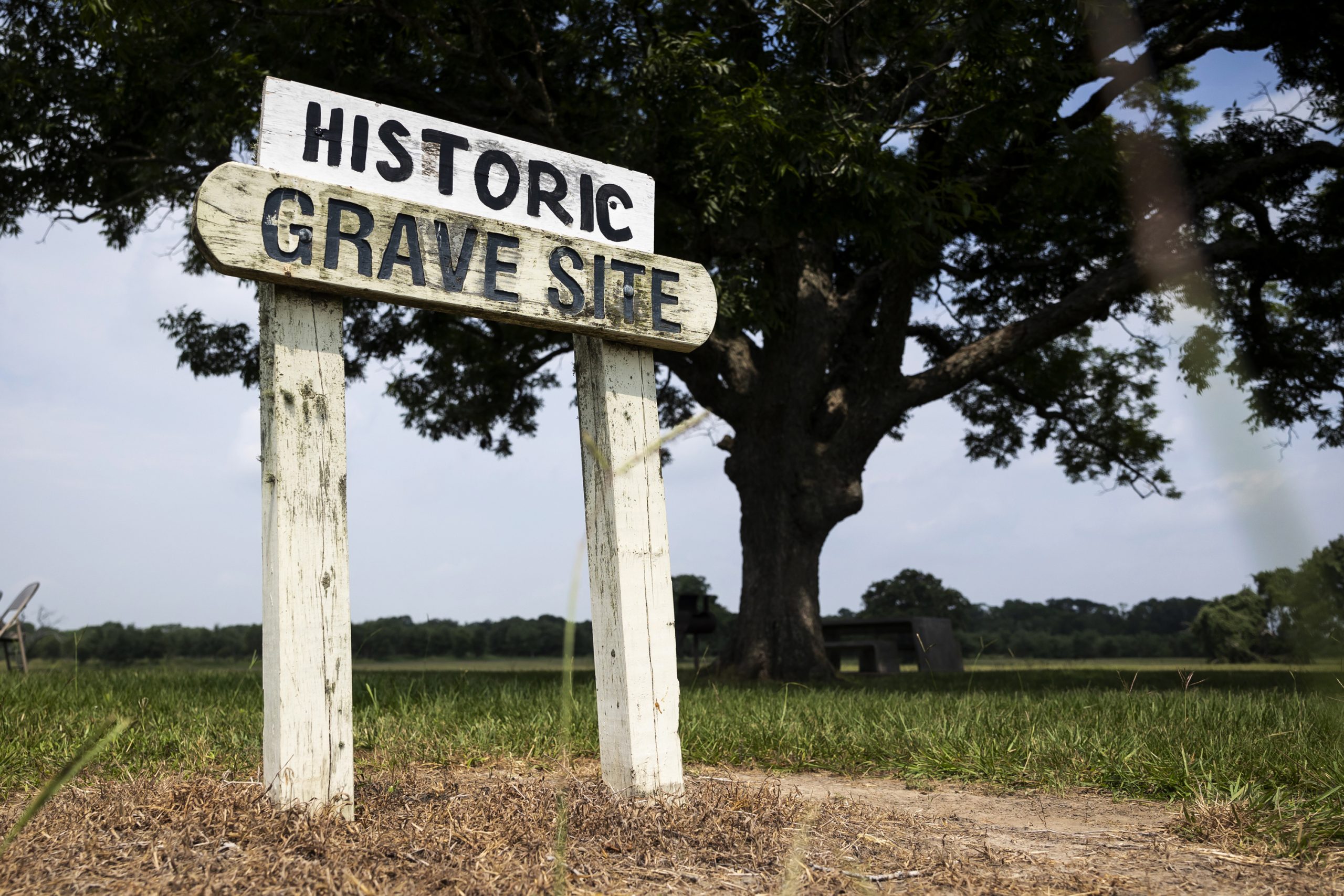 Painted sign directs people toward a grave site