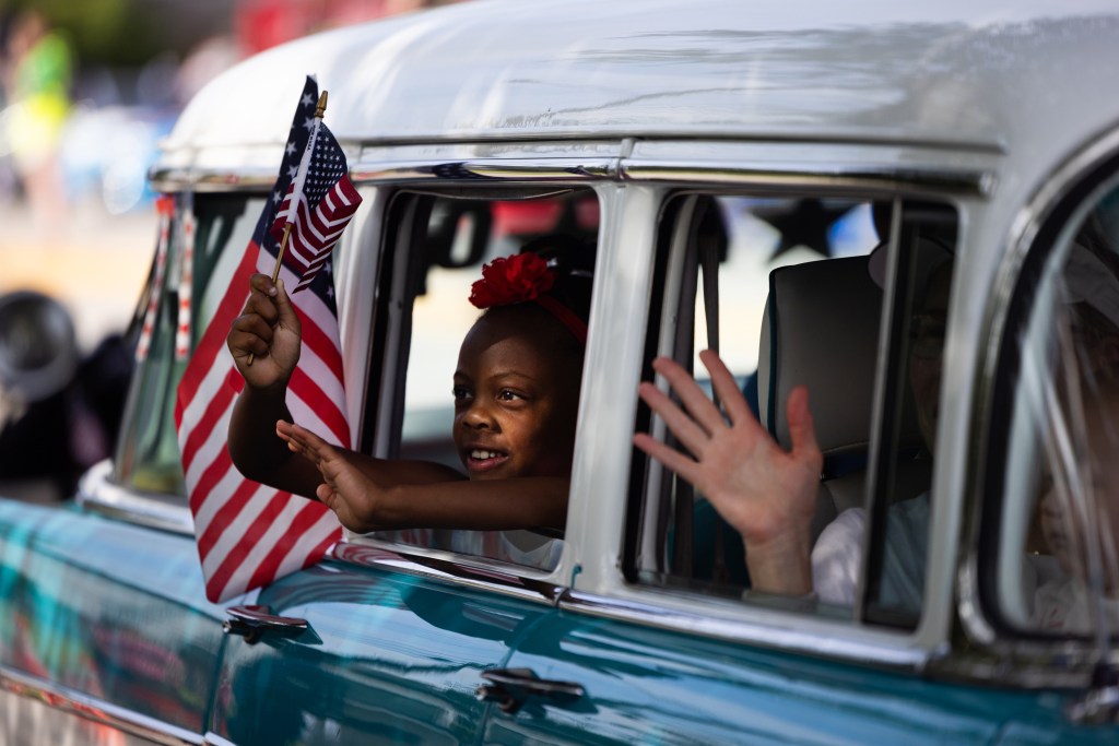 People ride classic cars on South Rice Avenue participating in the City of Bellaire’s Celebration of Independence Parade and Festival