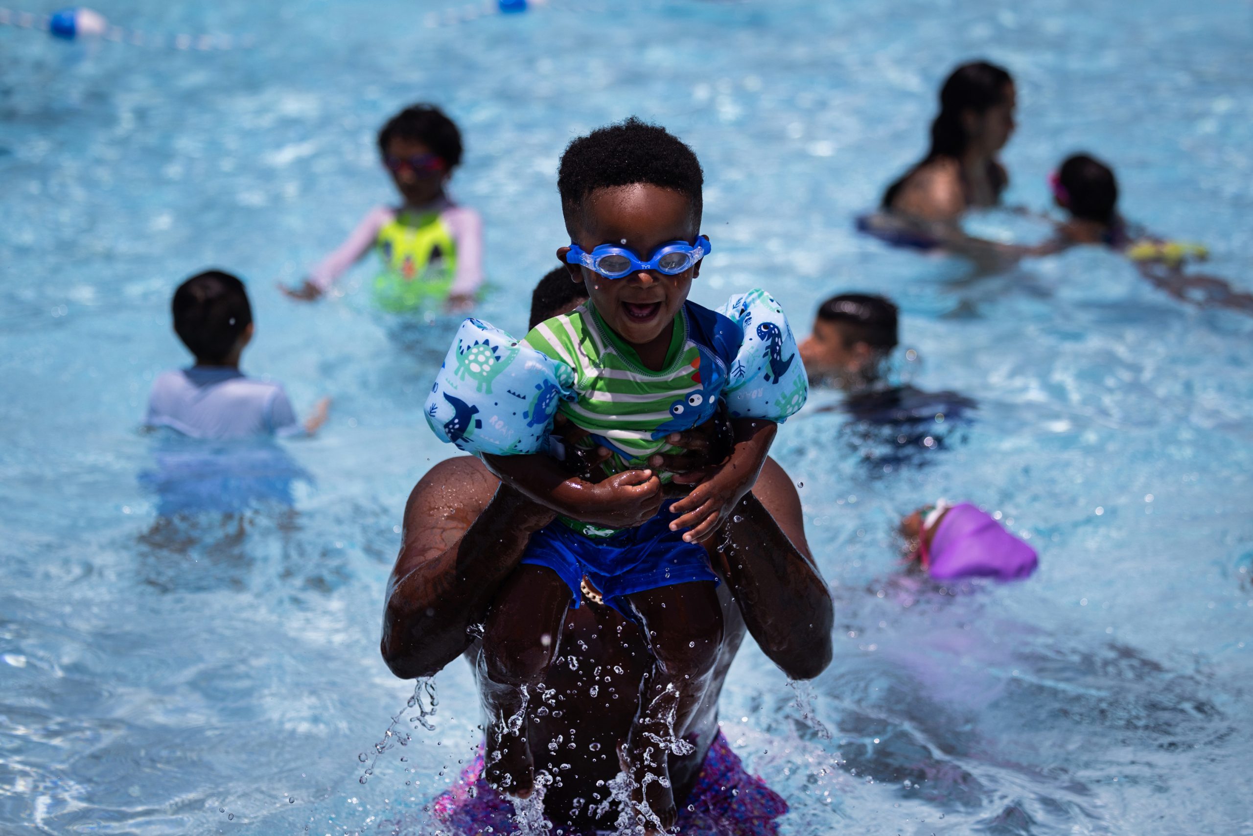 Sincere Gray, 2, is playfully lifted to the air by his father Derius Gray while enjoying the Alief Neighborhood Center and Park pool facilities.
