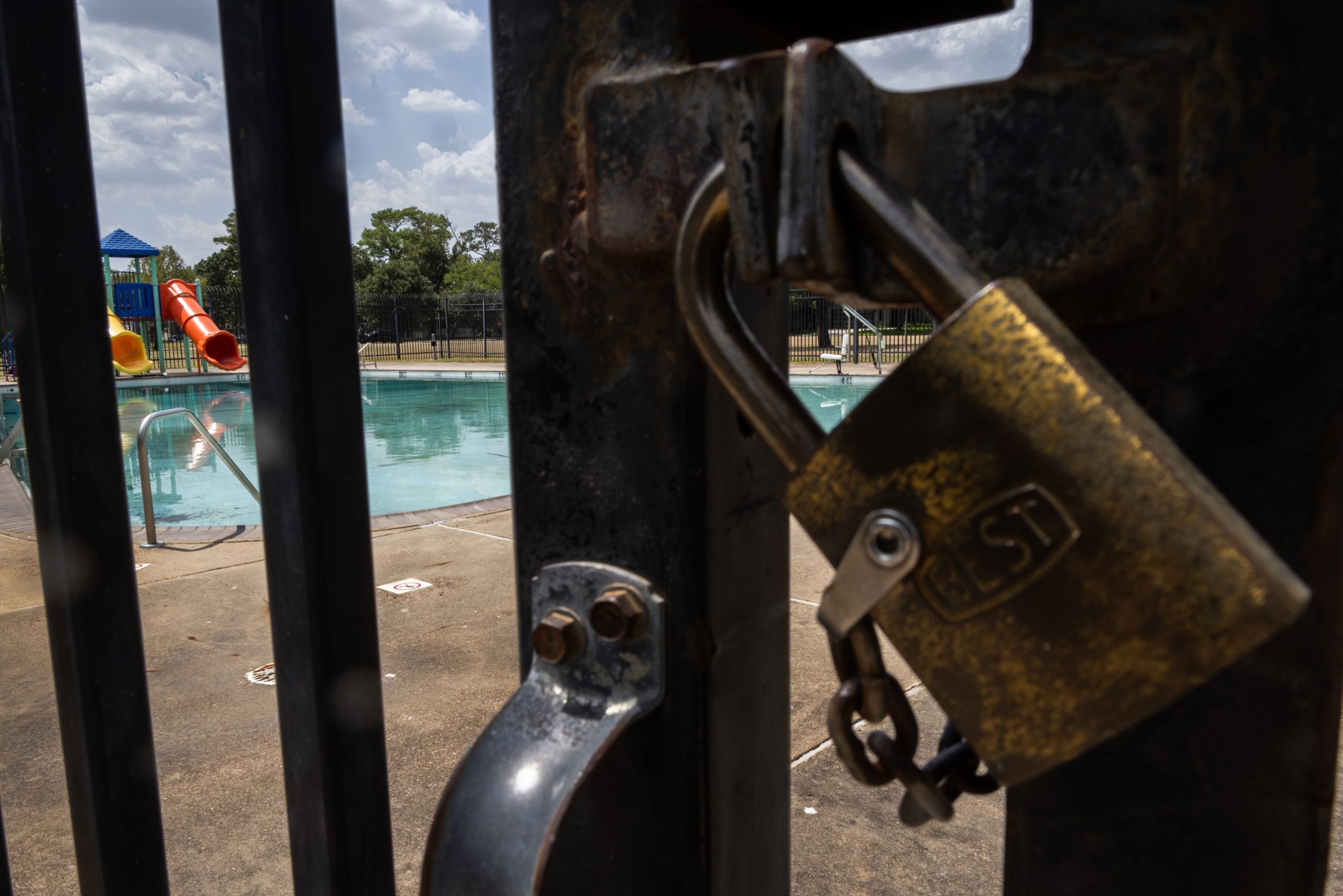 A lock keeps the gates of the Oak Forest swimming pool closed to the public, Friday, July 28, 2023, in Houston.