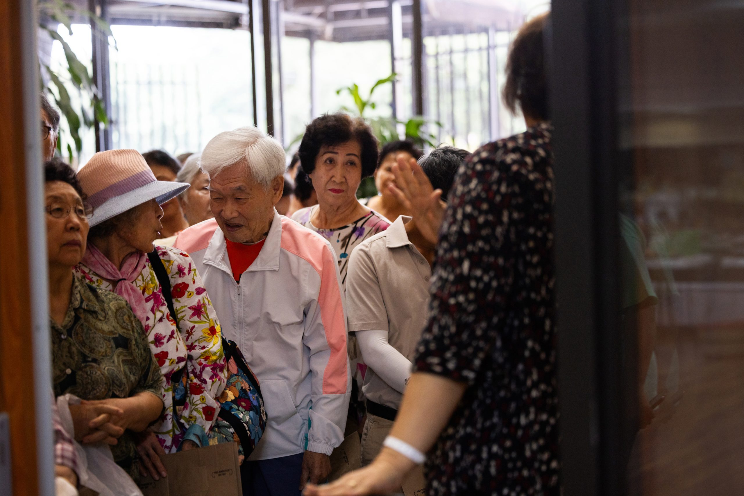 Members of the community wait for their turn to enter into a pop-up food distributing event at The Korean Community Center of Houston