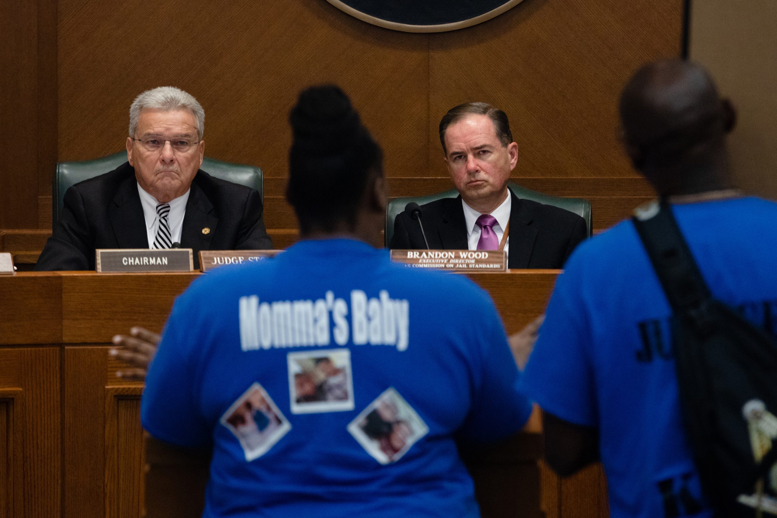 Tracey Woodson Smith and her husband, Kevin, hold a poster of their son, Kevin Jr., as they speak to members of the Texas Commission on Jail Standards