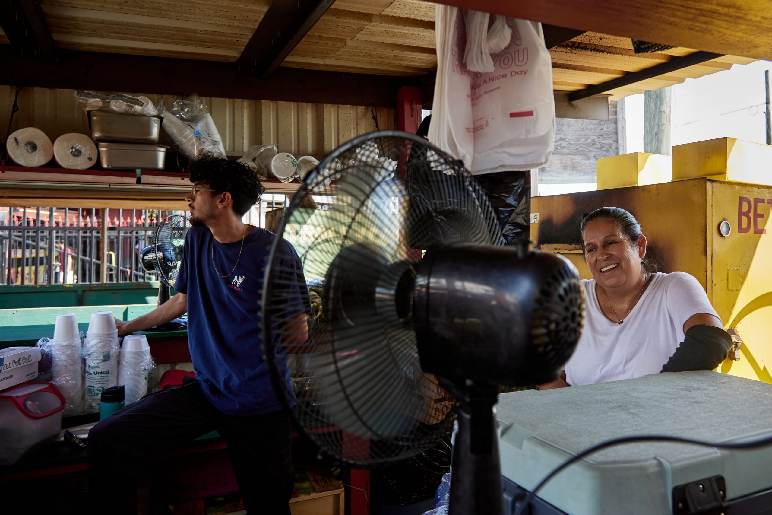 Alberto Yañez, left, and Maria Yañez stands near the heat of an oven and in front of a fan