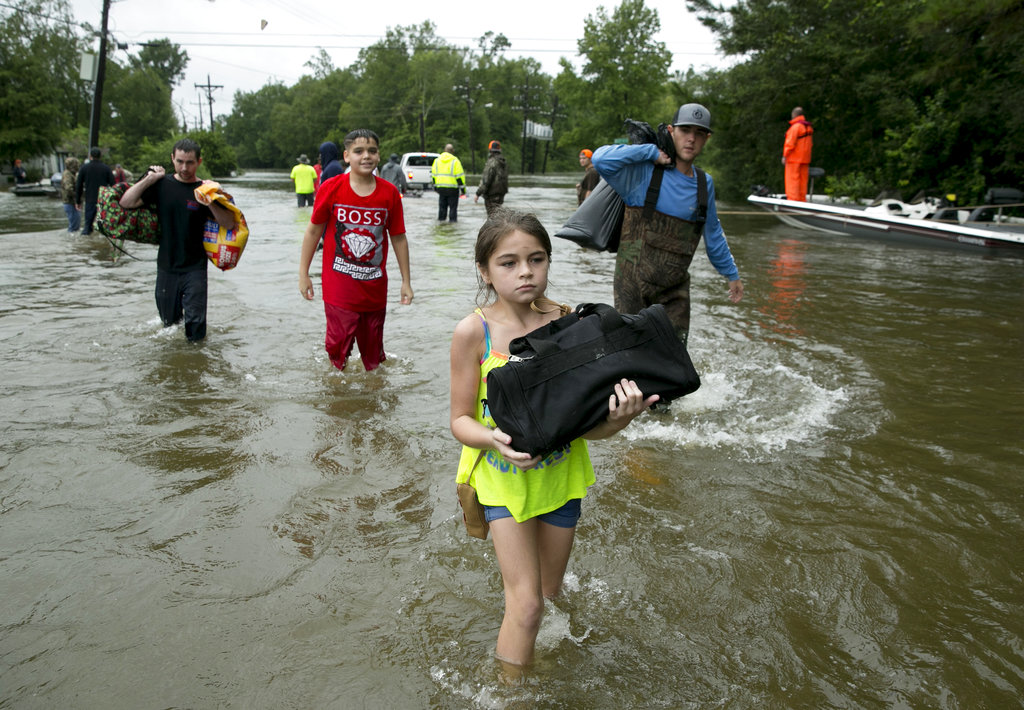 Jaylen Welch, 10, carries her belongings from her home after Tropical Storm Harvey struck Beaumont, Texas