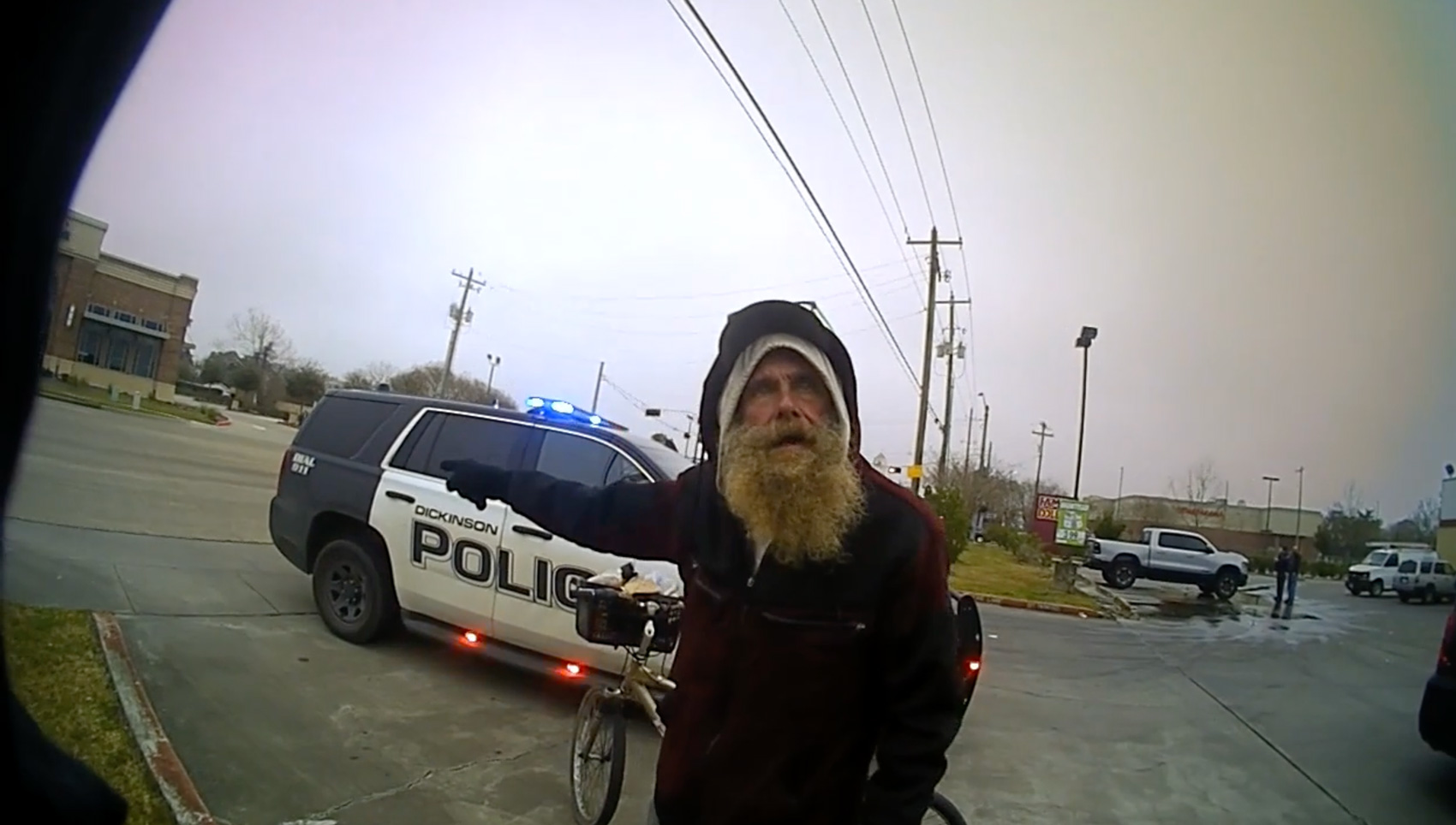 In a video screenshot, Michael Scurlock speaks with Dickinson Police Officer Michael Kinsley during a bike crash investigation Feb. 26, 2022, in Dickinson. Body camera footage subsequently shows Kinsley throwing Scurlock to the ground
