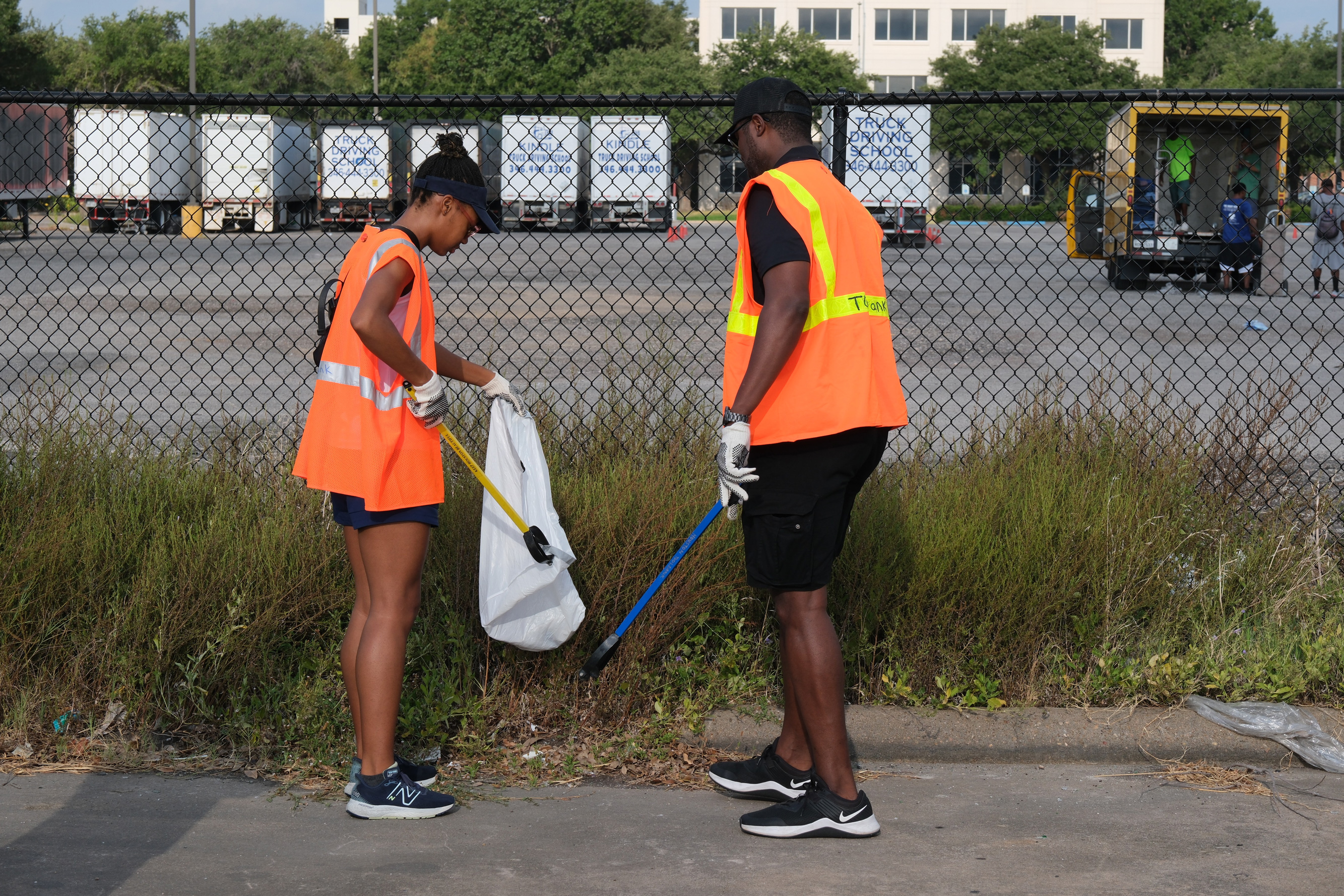 Representative of Councilwoman Sallie Alcorn’s Office, Justice Coutee, left, and Alief ISD Superintendent Anthony Mays, right, help in the cleanup efforts of the Bissonnet area. 
