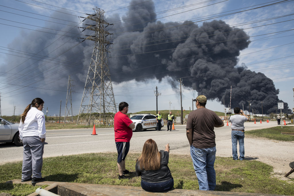 Residents look at the plume of smoke rising from a March 17, 2019 fire at the Intercontinental Terminals Co (ITC) petrochemical storage site in Deer Park, Texas