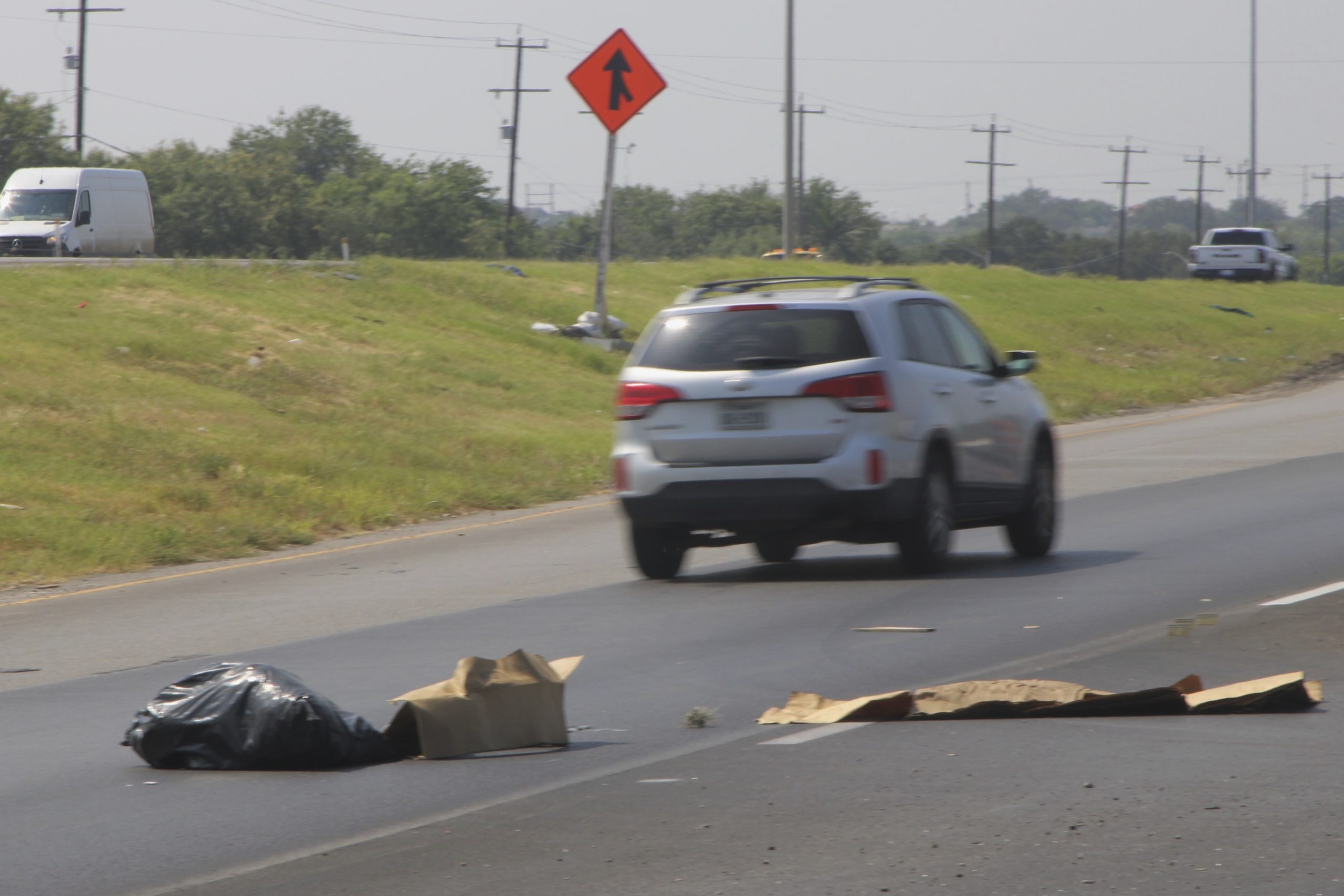 Automobiles avoid road debris along Interstate Highway Loop 410's frontage road in San Antonio