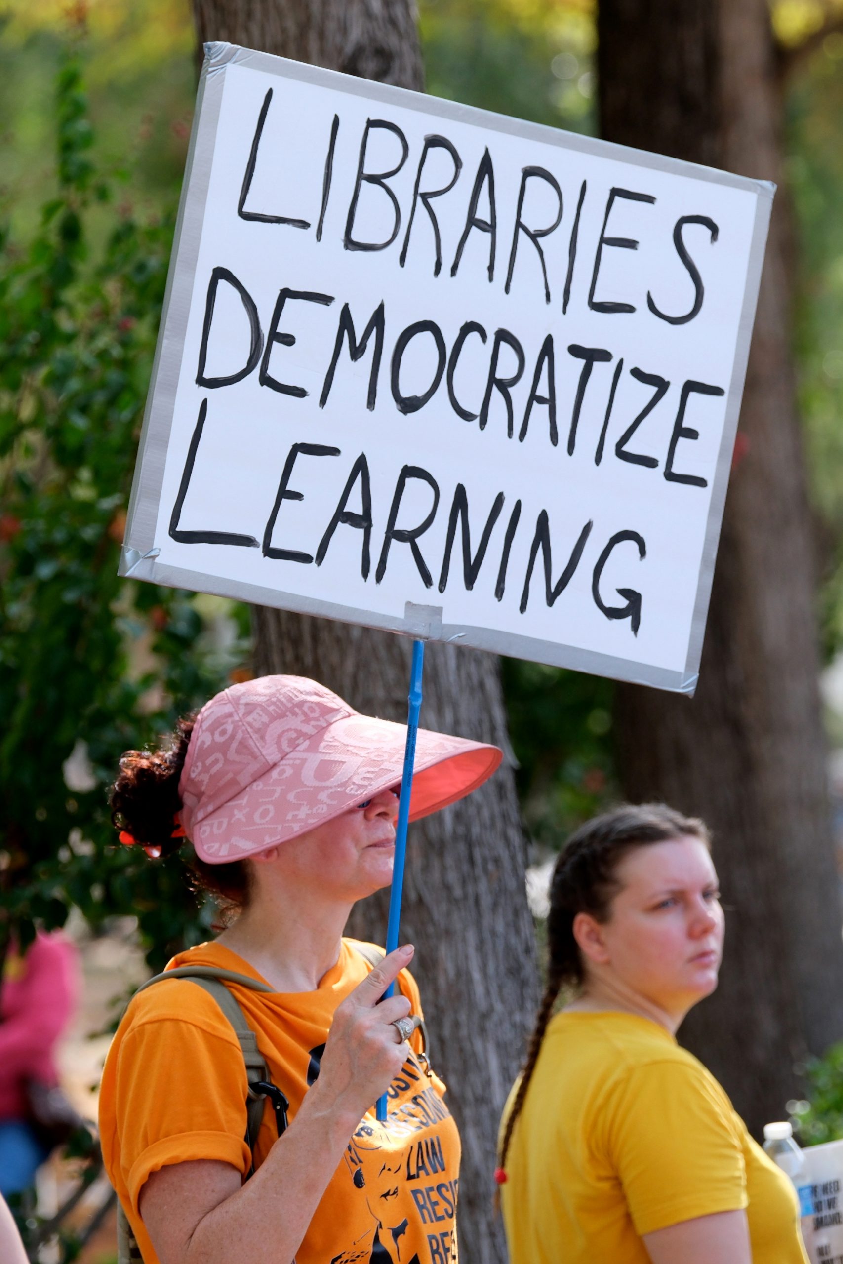 An attendee holds a sign in protest against the decision by HISD Superintendent Mike Miles to turn some school libraries into discipline rooms. 
