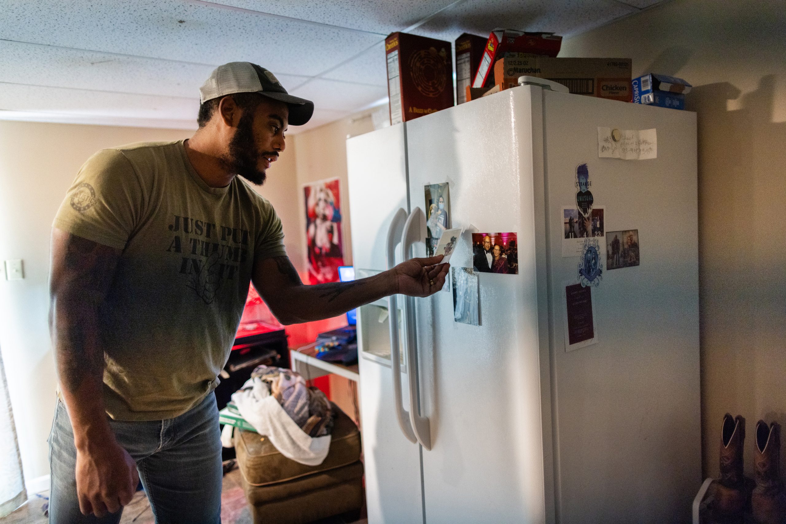 Aaron Morris, 27, pulls a photo of his family off the refrigerator