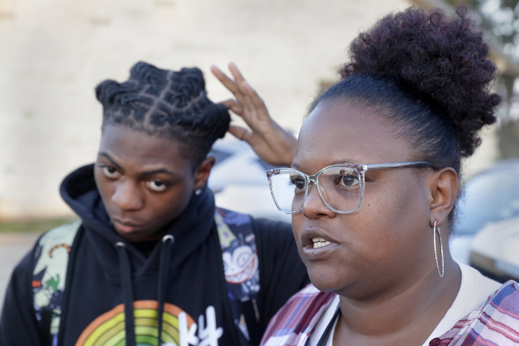 Darryl George, left, a 17-year-old junior, and his mother Darresha George, right, talk with reporters before walking across the street to go into Barbers Hill High School after Darryl served a 5-day in-school suspension for not cutting his hair Monday, Sept. 18, 2023, in Mont Belvieu.
